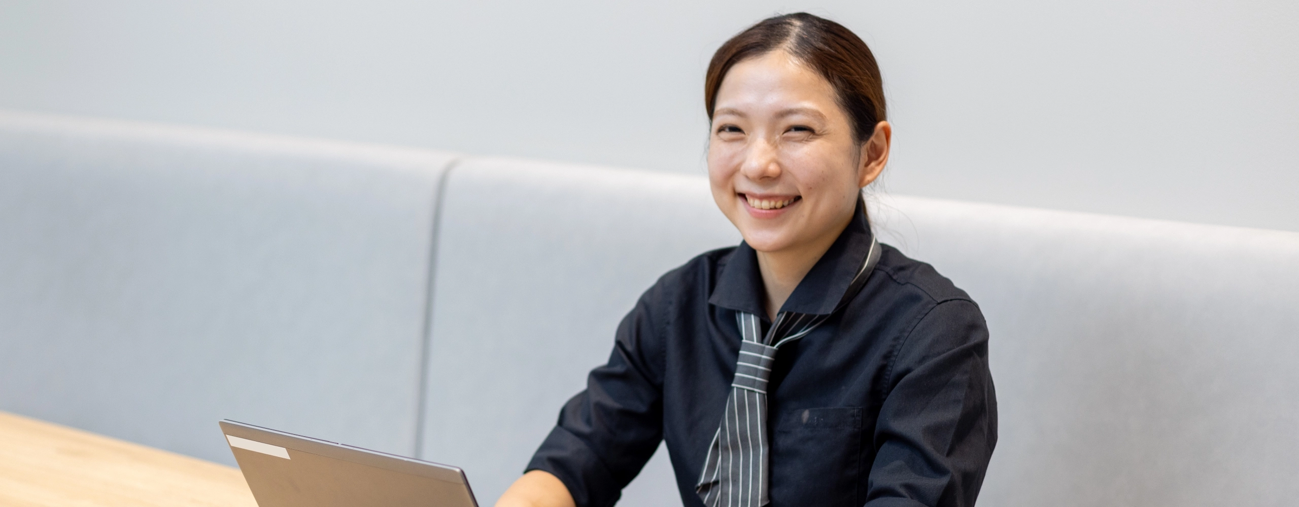 K.Y.さんインタビューキービジュアル　ソファ席に座っている笑顔の正面写真