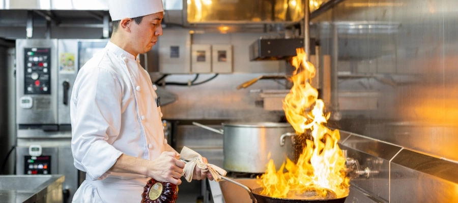 N.T.さん仕事風景　フライパンでフランベしている写真