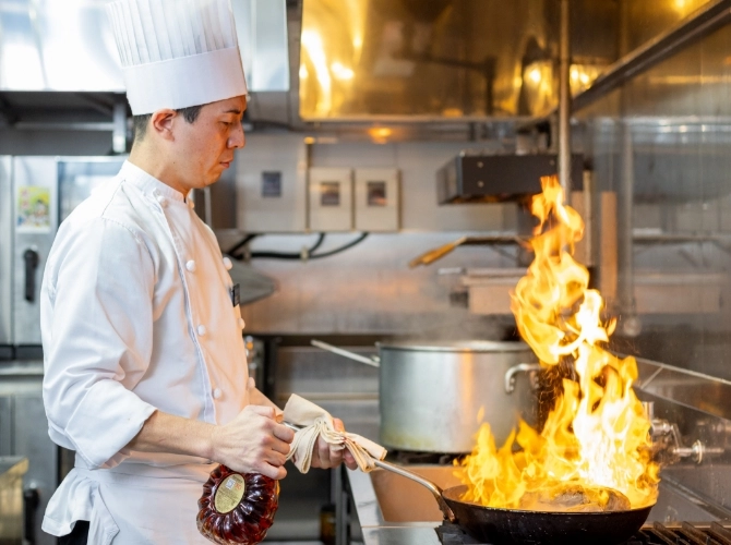 N.T.さん仕事風景　フライパンでフランベしている写真