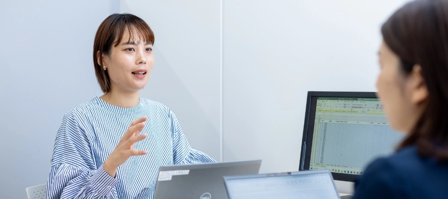 R.S.さん仕事風景　PCを見ながら打ち合わせをしている写真