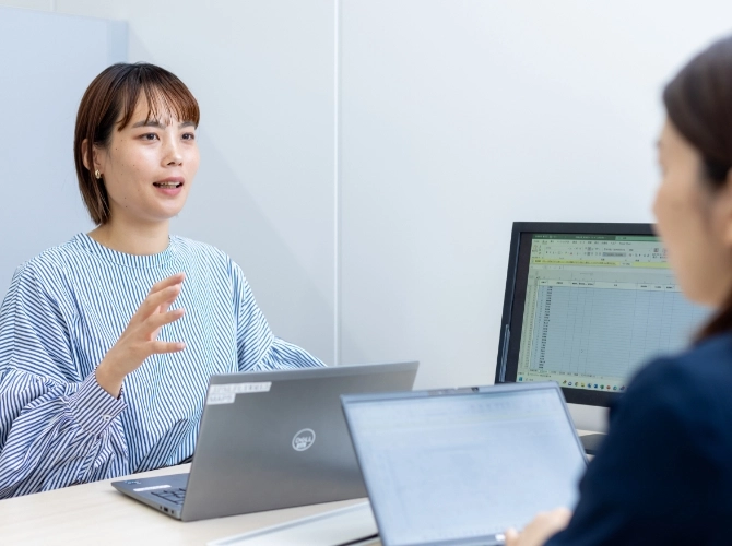 R.S.さん仕事風景　PCを見ながら打ち合わせをしている写真