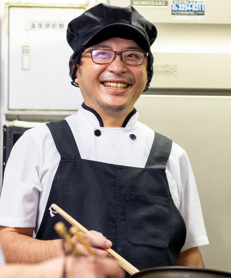 I.T.さんインタビューキービジュアル　厨房でスタッフと談笑している写真