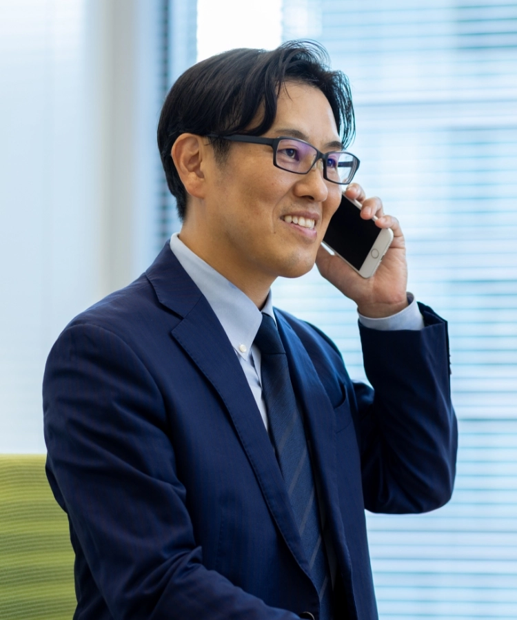 S.K.さんインタビューキービジュアル　大きな窓をバックに電話で会話している写真